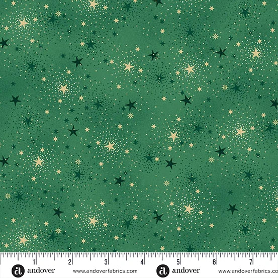 Green fabric with a scattered star pattern in black and metallic gold, shown flat with a ruler along the bottom edge for scale. Andover Fabrics branding is visible at the bottom.